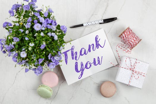 An elegant thank you card with flowers and a gift on a marble surface, perfect for expressing gratitude.